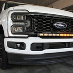 curved amber daytime running lights LED light bar installed on the bumper of white 2023 2024 ford superduty with 40in curved LED light bar on top of bumper white 2024 ford superduty 