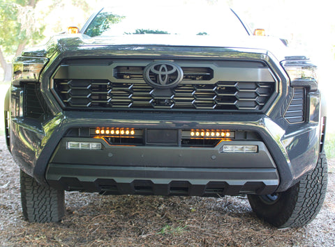 front view gray new toyota tacoma with led light bars behind grille and hood mount kit