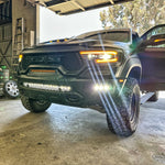 Black 2019-2024 RAM 1500 TRX with fog light kit white LEDs lit in the front bumper, front corner view