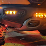 RAM Rebel fog light kit 2019-2024 with amber LED fog lights and light bar illuminated on front bumper at night