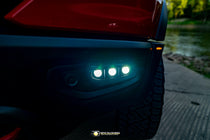 RAM Rebel fog light kit 2019-2024 with triple LED pods illuminated on front bumper at dusk
