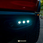 RAM Rebel fog light kit 2019-2024 with triple LED pods illuminated on front bumper at dusk