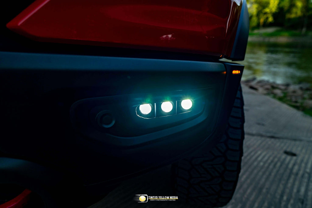 RAM Rebel fog light kit 2019-2024 with triple LED pods illuminated on front bumper at dusk