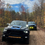 RAM Rebel Light Bar on 2019-2024 RAM 1500 Rebel trucks driving through a wooded dirt trail with LED lights on
