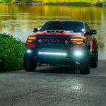 Red RAM 1500 with RAM Rebel Light Bar single 40in slim light bar illuminated at river boat ramp front view