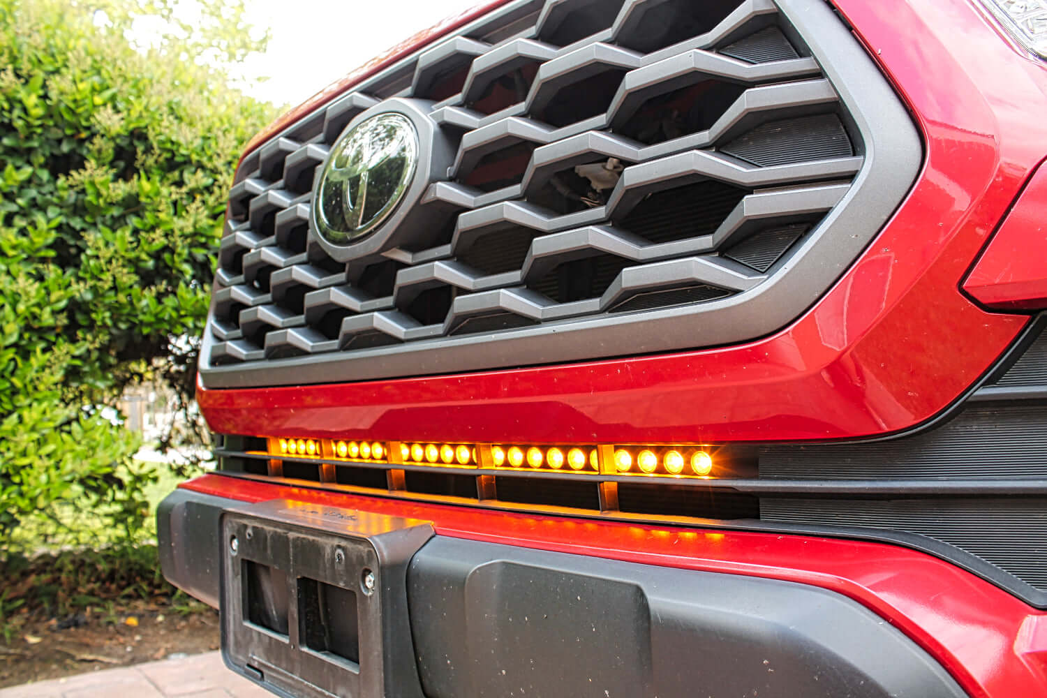 2020 2021 2022 2023 upclose red Toyota Tacoma with one amber 30in Light Bar